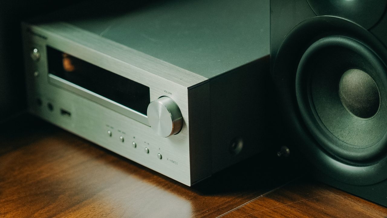 Close-up of a high-end audio receiver with speaker, steel finish.